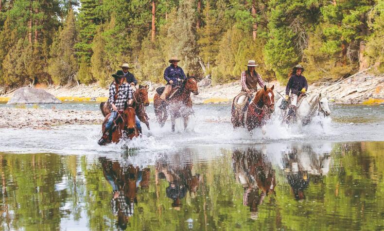 ブラックフット川の岸辺での乗馬をお楽しみください。 家族旅行 アメリカ西部の乗馬