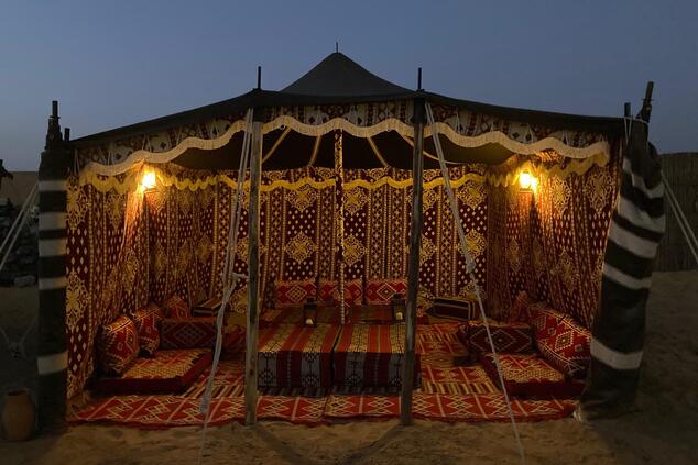 カーペットや刺繍の布で飾られた典型的なベドウィンのテント。 ベドウィン砂漠での食事体験 ドバイ