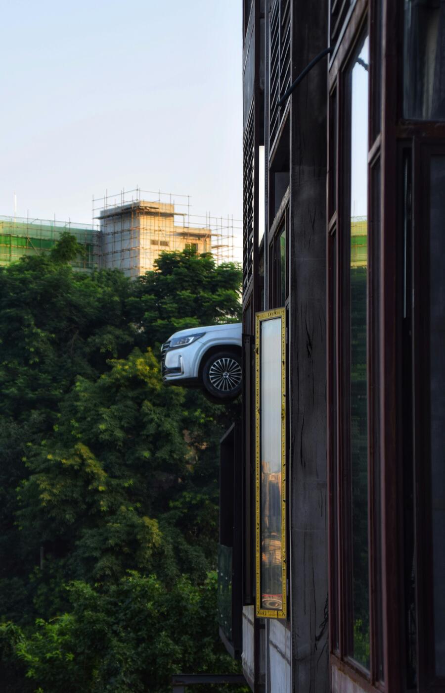 ショップのウィンドウでさえ重力に逆らいます。ビルのファサードに設置されたこのインスタレーションは、不可能が日常に見えるこの街で、吊り下げられた自動車をアーバンアートの作品に変えました。写真:チェンユー・グァン 写真チェンユー・グァン重慶。中国。